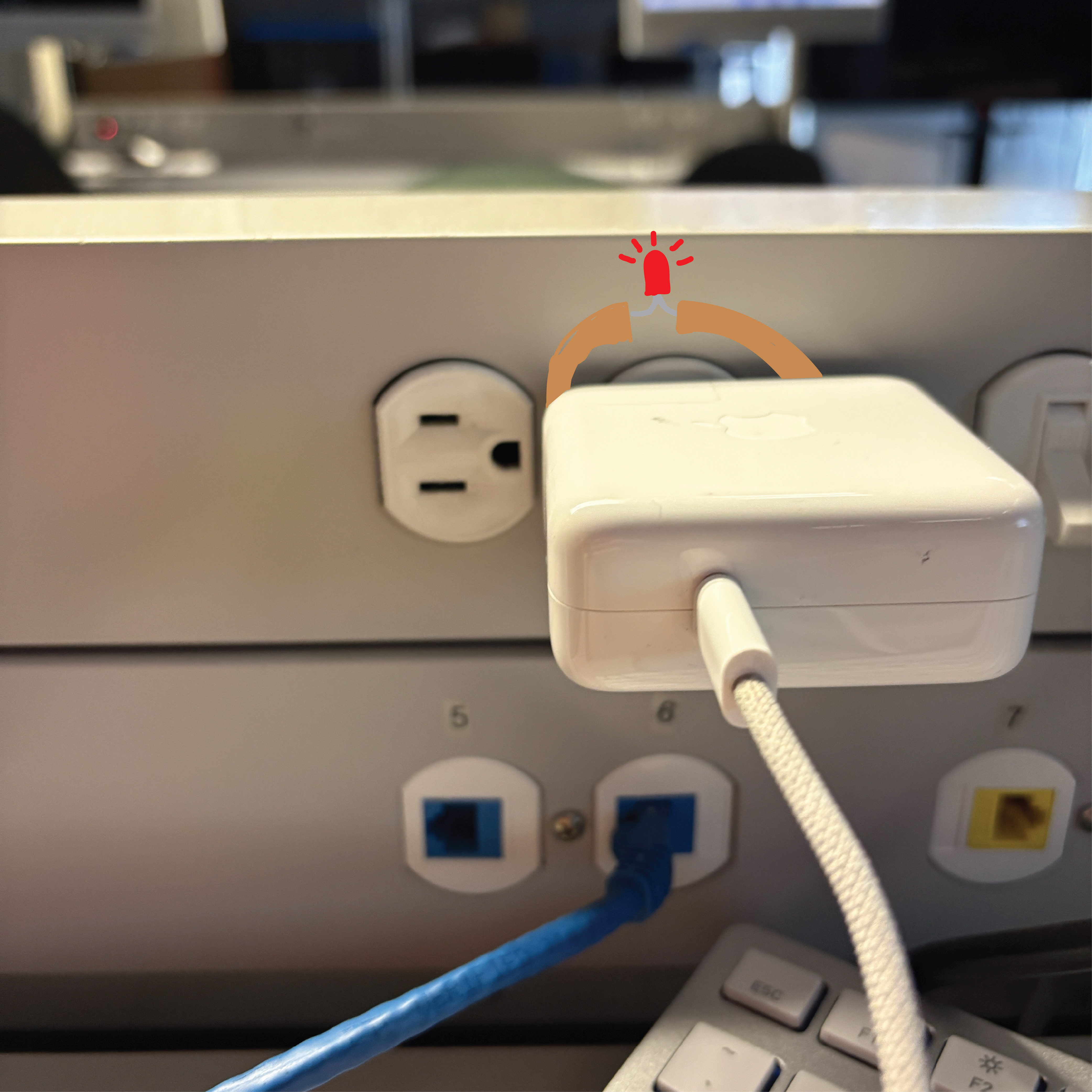 A circuit that shows a non-wearable circuit that closes as the mac charger gets plugged into the wall, causing the LED to activate as the copper tape and battery allows current to flow to the circuit on the wall.