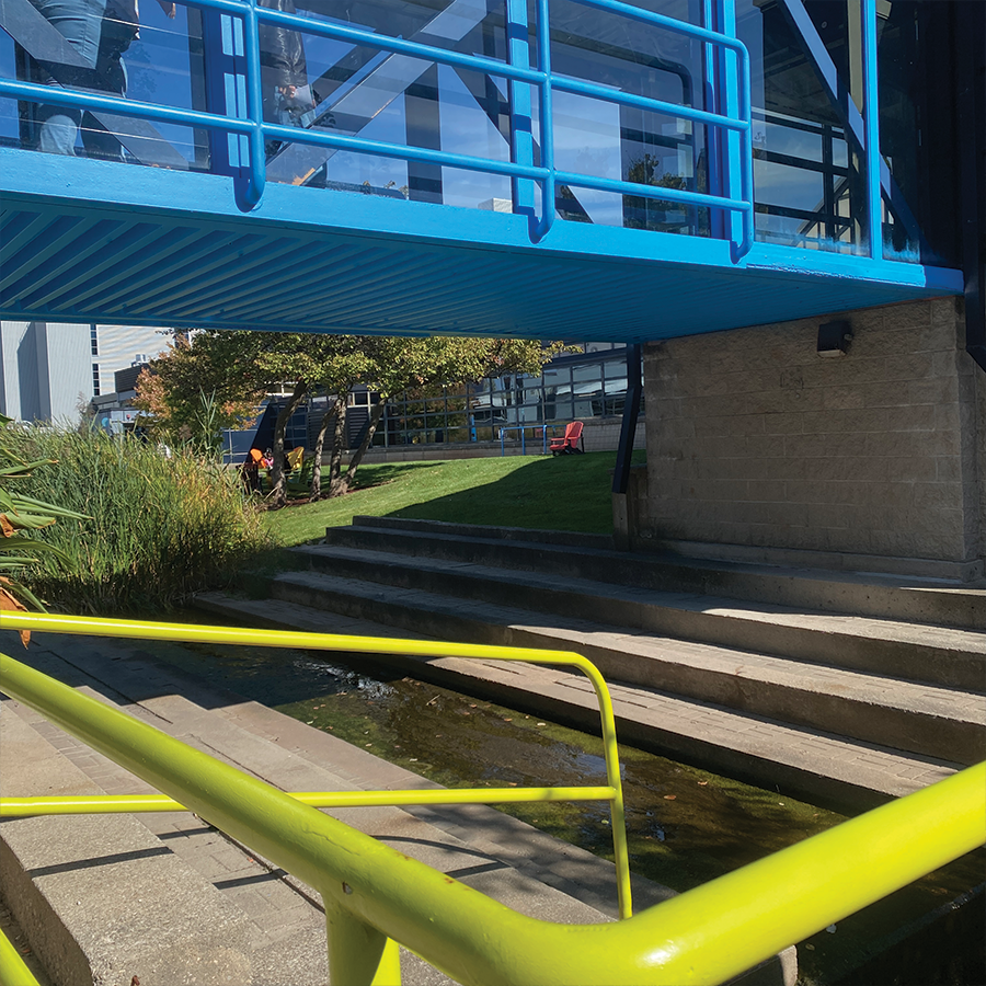 The exterior/below the connecting bridge between the two main buildings of Sheridan. Stone, steel, and glass are the most prominient materials used in this structure.