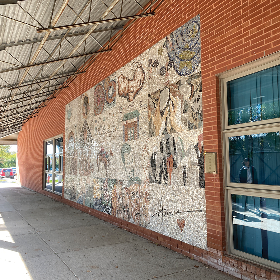 A mosaic wall outside of the Annie Smith building, made out of small coloured tiles. This is here to add meaning to the building, as it says Annie on it, as well as it portraying a various collage of abstract images.